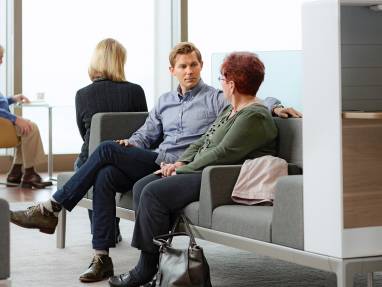 Man and woman sitting comfortably on Regard lounge seating