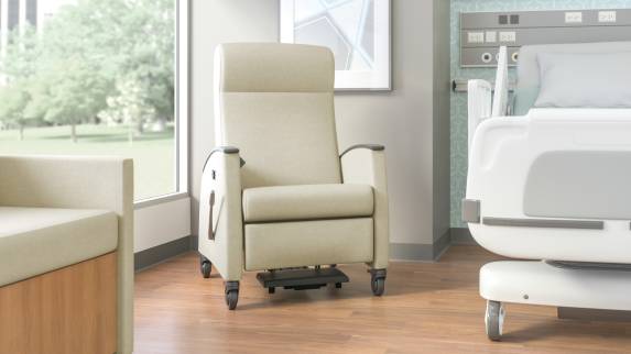 Off-White Mitra Recliner next to a hospital bed in a medical recovery room