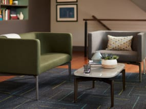 Two Bivi Rumble Seats in green and gray upholstery around a Bassline Table in an office lounge