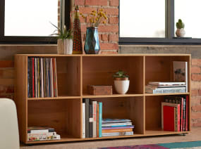 Books and plants are displayed on a Bivi Depot, 2-shelf style shelf