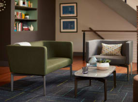 Two Bivi Rumble Seats in green and gray upholstery around a Bassline Table in an office lounge