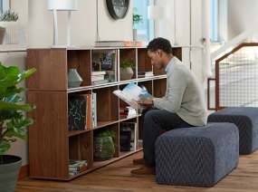 Items are stored on a Bivi 3-High Depot shelf, there is a man reading in front of it.
