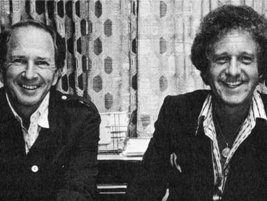 Two men smiling in a black and white photo