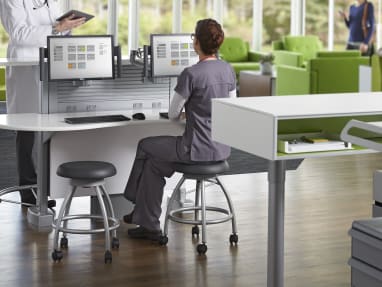 Nurse sitting on Verge stool in front of Sync workstation speaking with a doctor
