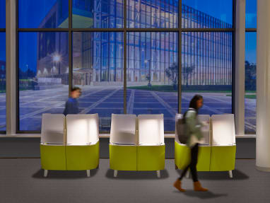 Three lime green Brody WorkLounges in front of big windows on a clear evening