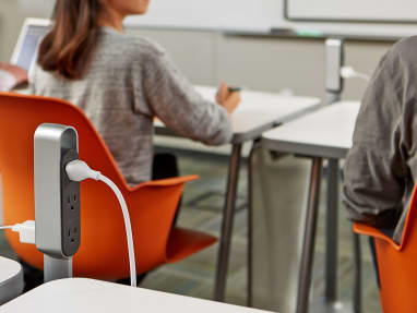 Thread Power Outlet in a classroom setting in between two desks