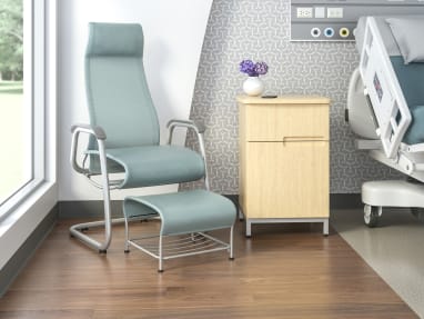 High-back Cura patient chair with a sled base and ottoman in a medical patient room