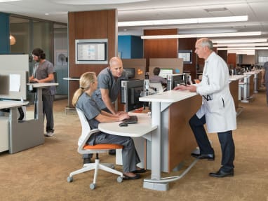 Healthcare professionals work in a space with Cobi desk chairs and a Steelcase Sync desk system