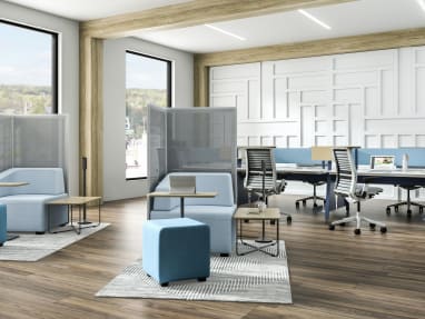 Open office with two light blue B-Free Big Cube Lounge Chairs and B-Free Cube Ottomans and B-Free Coffee Tables with a light wood finish