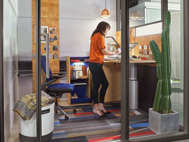 creative private work area with adjustable height desk and glass walls