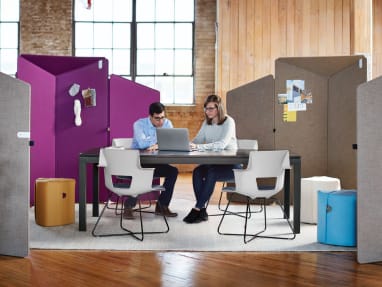 2 people collaborating in the office with surrounding privacy screens