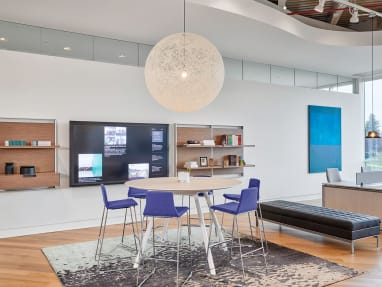 A group of Montara650 stools are arranged around a Potrero415 table. Nearby, a group of workstations have Gesture desk chairs by Steelcase next to them.