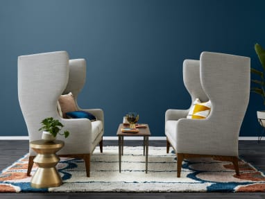 two large tufted gray sofas with a slim coffee table between them