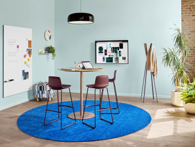 Meeting space with Coalesse Enea Lottus stools around a Montara650 table. A Blu Dot Splash coat rack and PolyVision Sans CeramicSteel whiteboard are also seen.