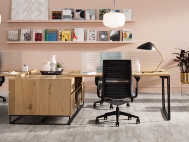 A workstation created with West Elm Work Greenpoint Benching is shown with Steelcase Think desk chairs