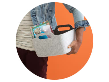 Up-close image of a person holding a Steelcase Flex accessories basket with supplies inside it.