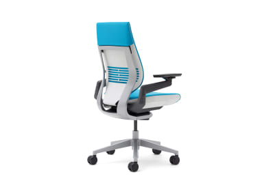 A blue, wrapped-back gesture chair from the back with the seat facing the right