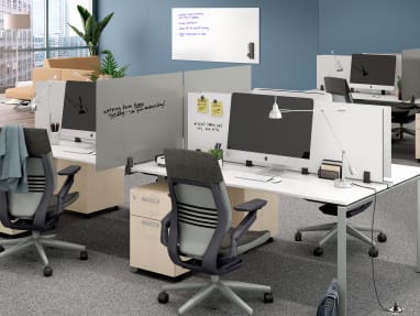 Office space with PolyVision Boundri™ screen dividers between individual workstations, black Gesture chairs and white desks.