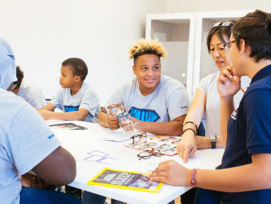 5 students collaborating inside a classroom