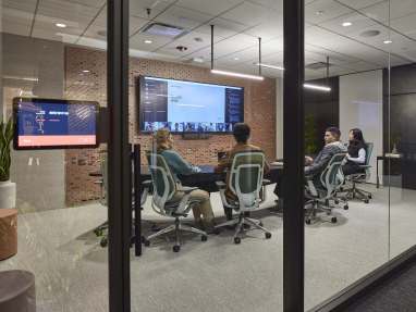Business meeting in a private room with screens using Karman chairs and ocular table from steelcase