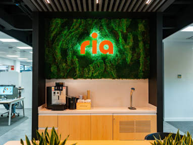 Zona de descanso y punto de encuentro en oficina moderna con diseño de interiores y mobiliario de oficina funcional