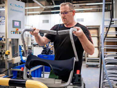 Steelcase worker assembling a chair in an industrial environment