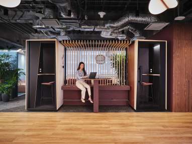 Orangebox Be my guest® phone booth with canopy and wall in-between in an open space environment