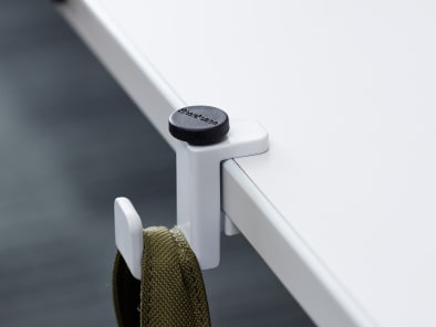 SOTO Personal Hook attached to the edge of a table with a bag hanging on it