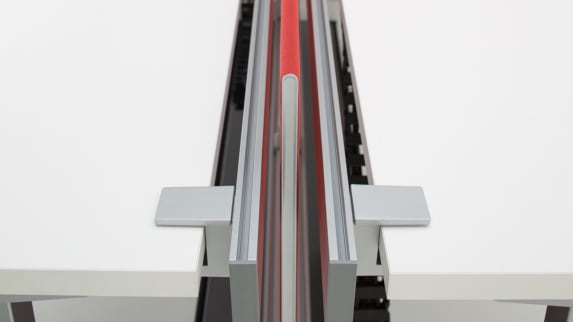 SOTO Rail with a red screen divider in between two white desk surfaces