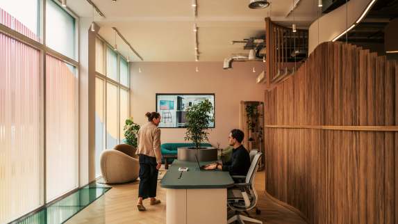 People seated and standing in an open space environment at the London Worklife Center
