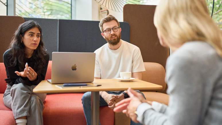 3 people discussing while seated on the Coalesse Ensemble Lounge System at the Munich LINC.