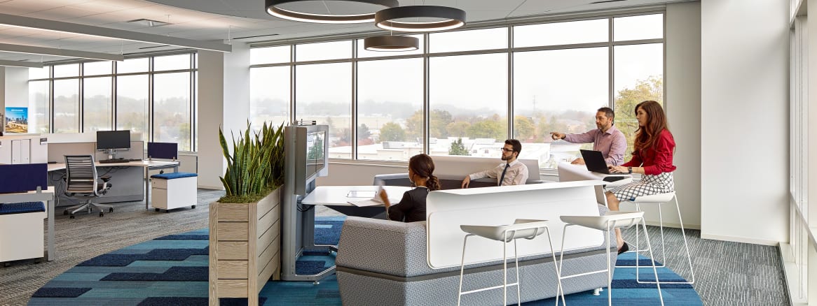 People gather in a Steelcase media:scape lounge with Scoop stools