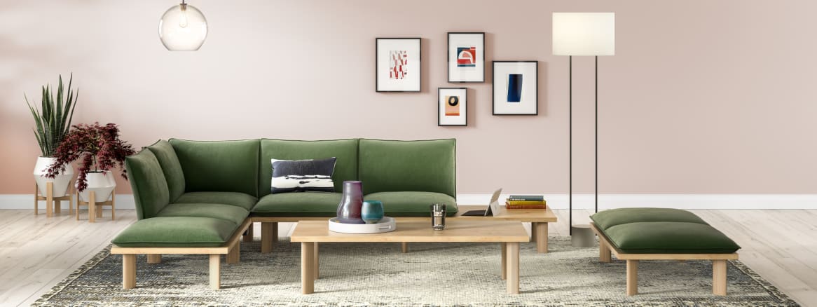 A West Elm Work Boardwalk lounge sofa with green cushions around a West Elm Work Boardwalk rectangular coffee table
