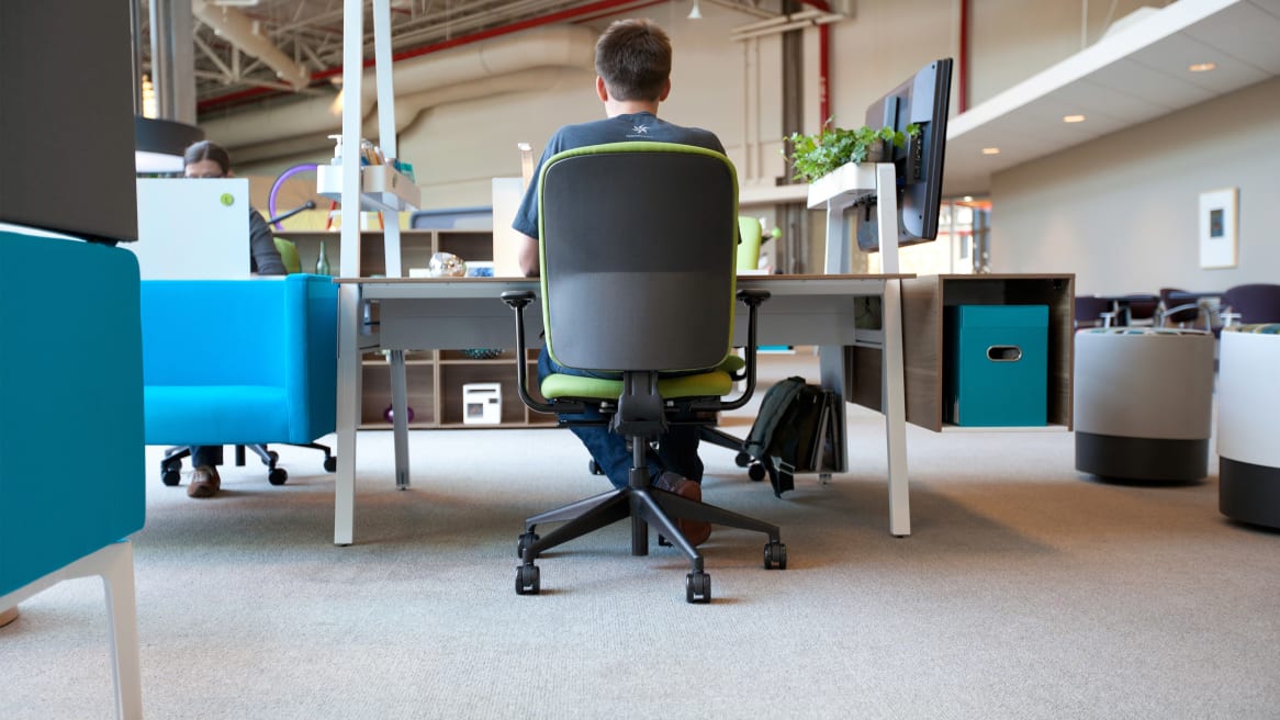 Rear view of worker sitting at a Bivi desk in a Green Jack Task Chair
