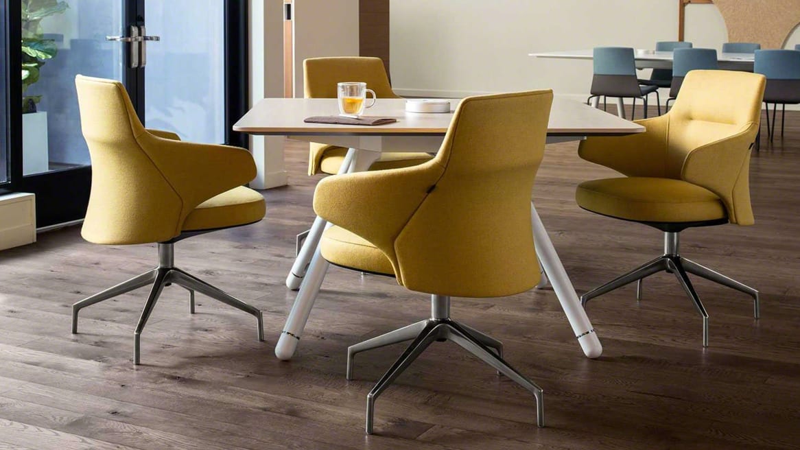 Four yellow Massaud low back chairs around a Potrero415 square table with an integrated PowerPod