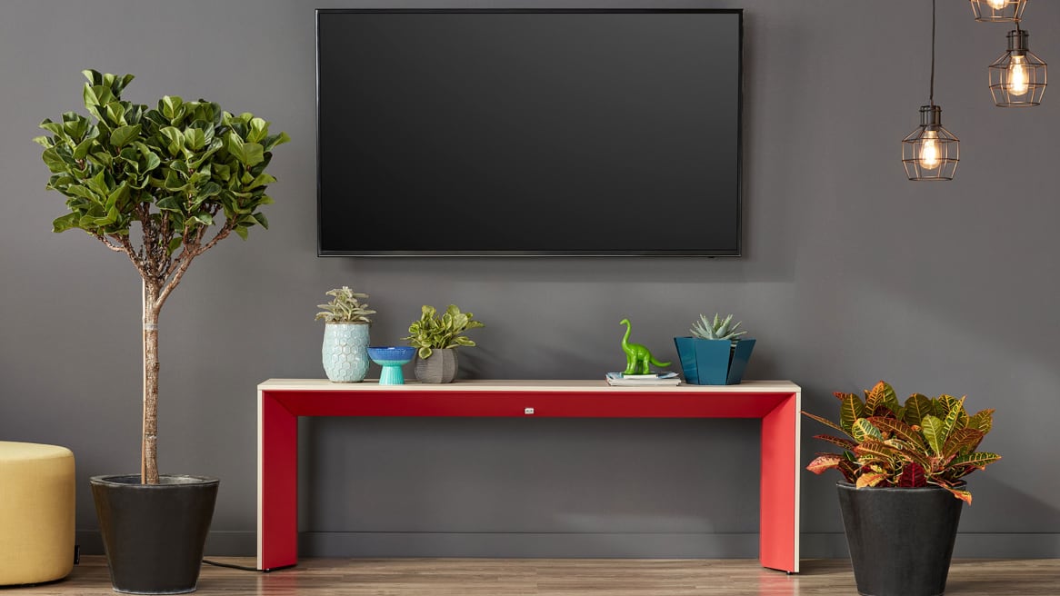 A red and white Campfire Slim Table against a wall under a TV