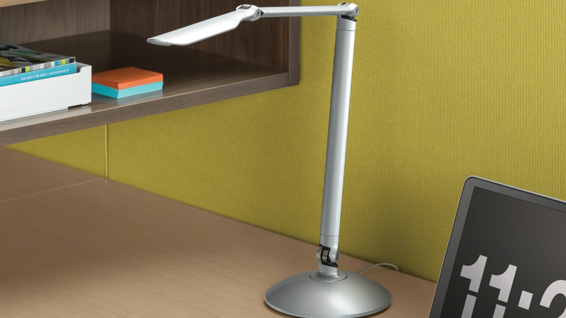 Silver LED Linear Desktop Task Light on desk next to a wooden storage