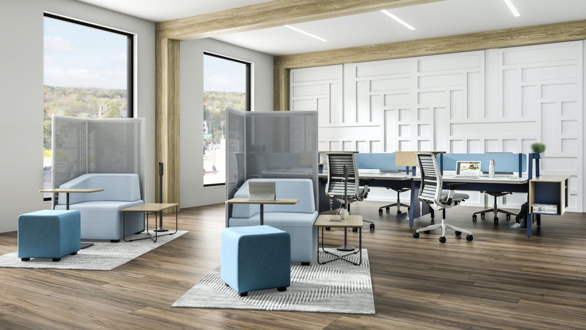 Open office with two light blue B-Free Big Cube Lounge Chairs and B-Free Cube Ottomans and B-Free Coffee Tables with a light wood finish