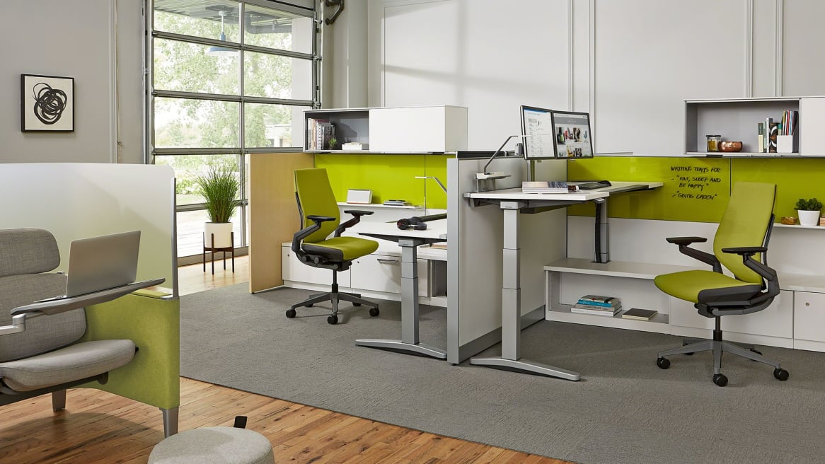 Ology desks with computers on it and green Gesture chairs