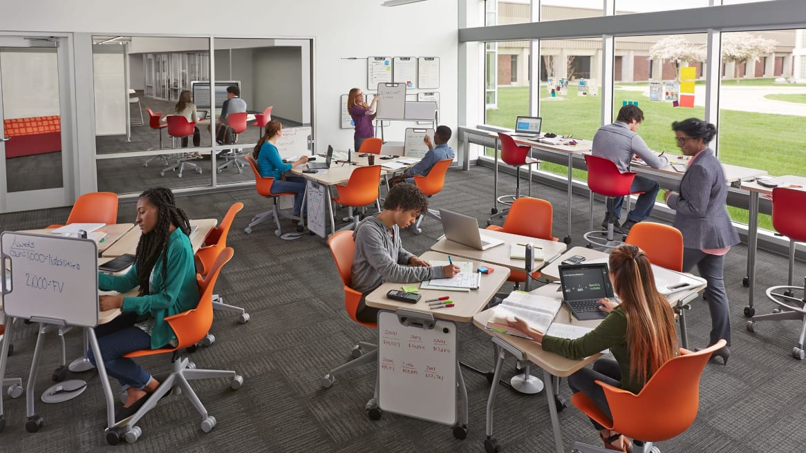 Active classroom with Orange Node Chairs and light maple finish Verb tables