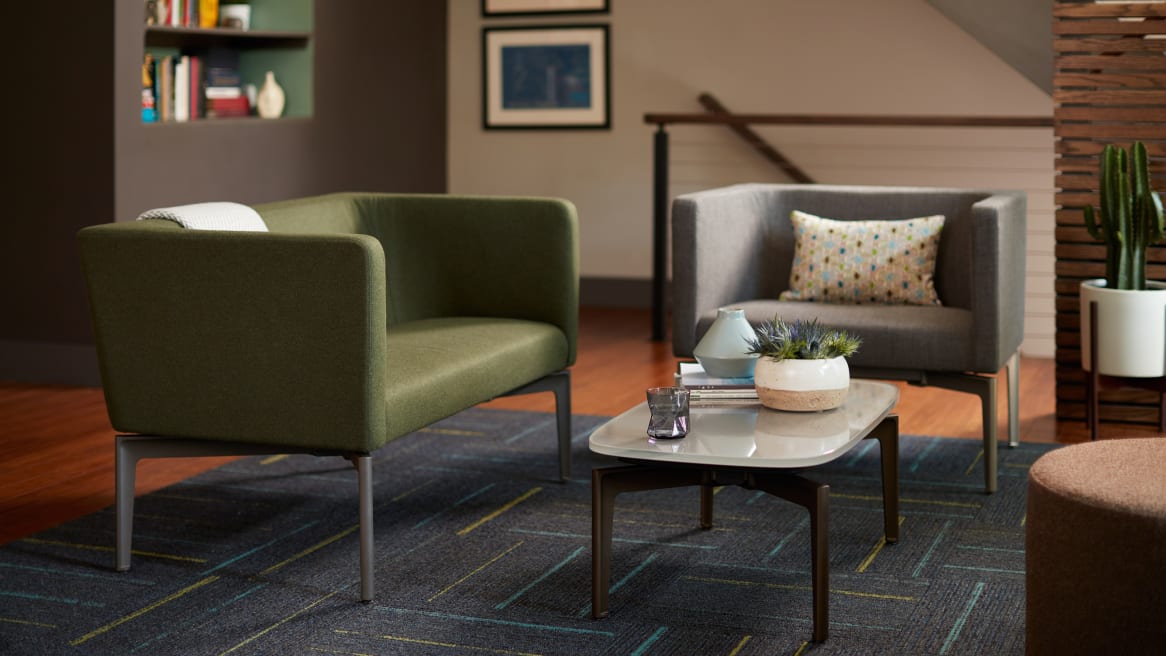Two Bivi Rumble Seats in green and gray upholstery around a Bassline Table in an office lounge