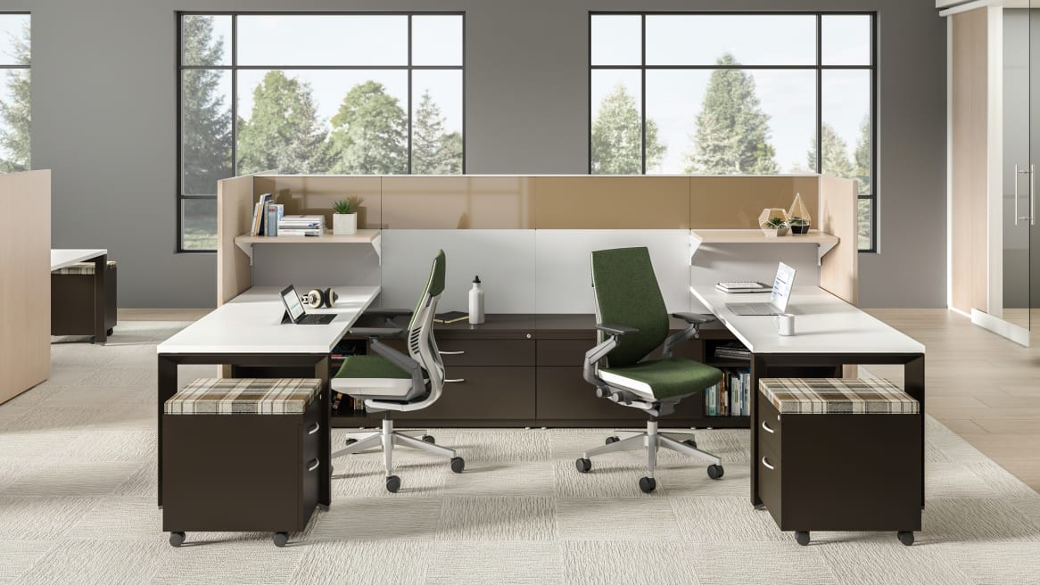 A workstation consisting of Answer panels, VIA walls, Gesture chairs from Steelcase with green upholstery, and TS series storage with plaid upholstery