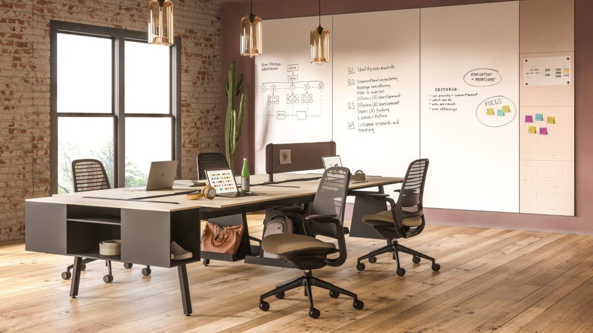 A PolyVision Motif Collaborative panel system mounted to the wall next to a Bivi desk workstation with attached Bivi Trunk and Steelcase Series 1 chairs