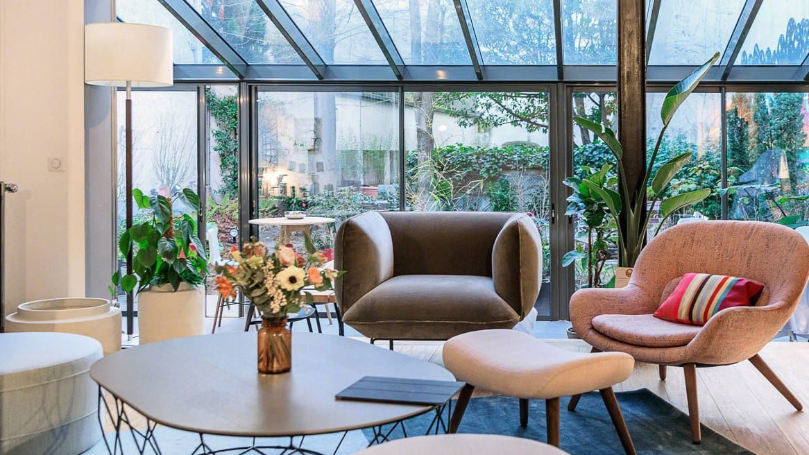 Bolia Steelcase products are shown in a lounge setting with a Comb round coffee table in the center of the space and a Cloud armchair and Philippa armchair next to it