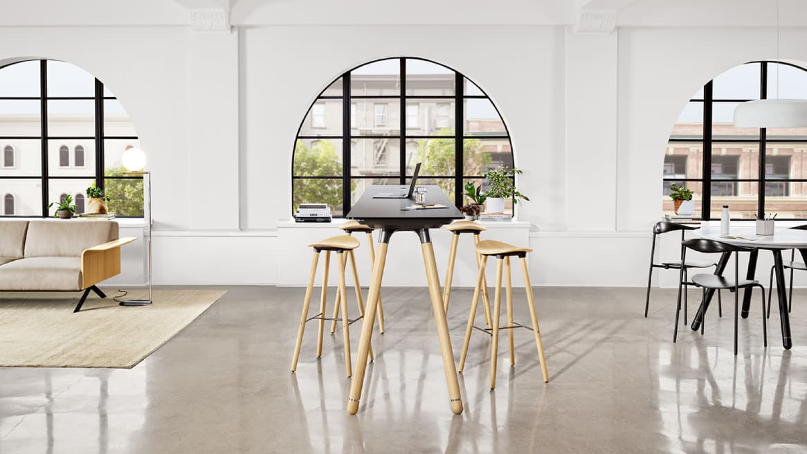 A Potrero415 Light table with wood legs and black top and Enea Cafe wood stools around it