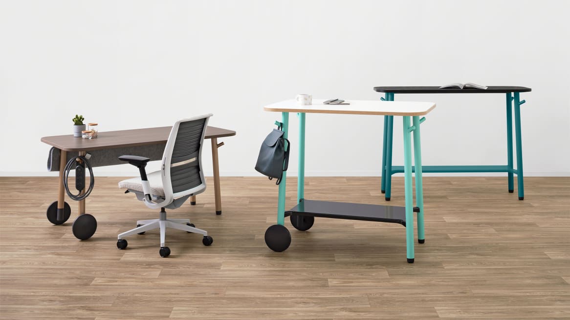 A Steelcase Flex seated height table is shown with a Think desk chair A Steelcase Flex standing height table and a Flex Slim table are seen nearby