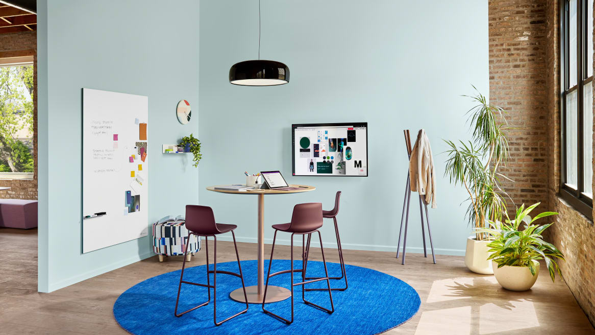 Meeting space with Coalesse Enea Lottus stools around a Montara650 table. A Blu Dot Splash coat rack and PolyVision Sans CeramicSteel whiteboard are also seen.