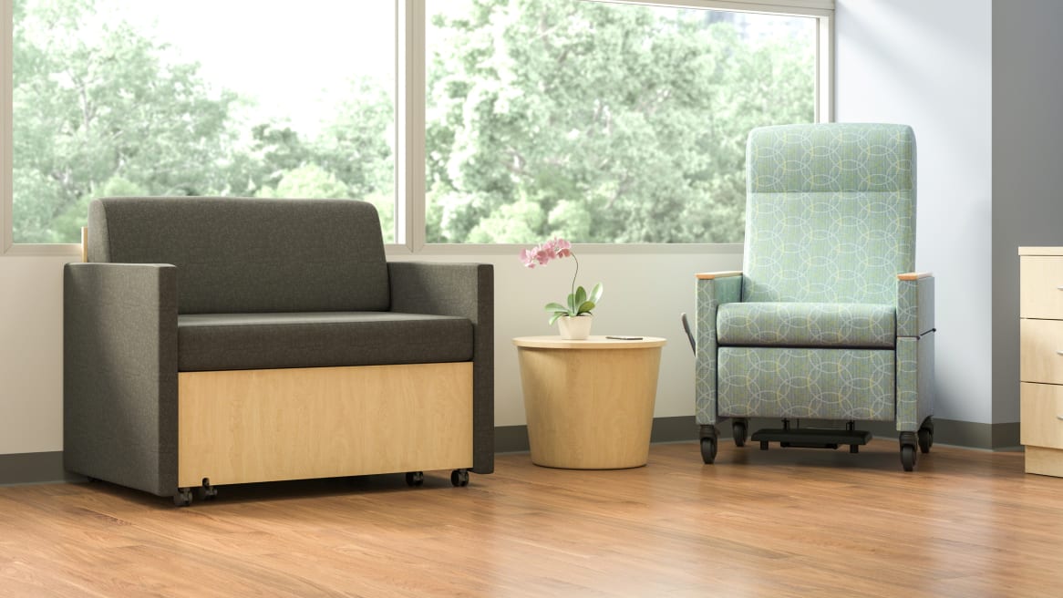 Mineral Patient chair in mint green, next to a brown X-tenz Double Sleeper with a small coffee table in the middle of them.