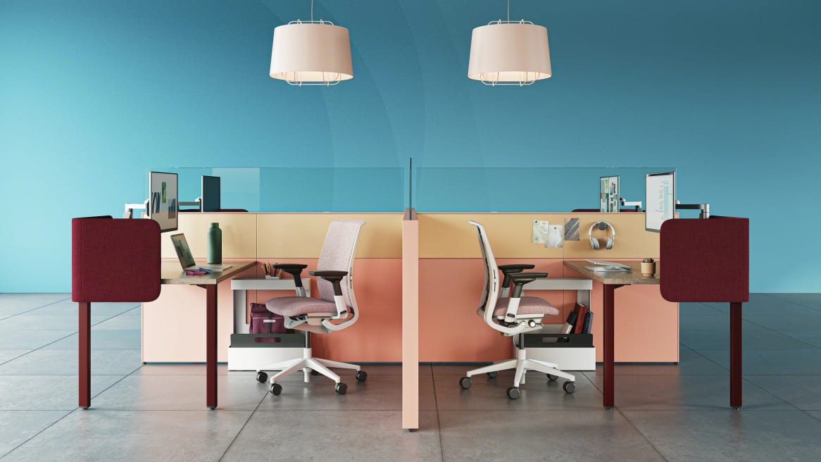 work space divided with pink walls, two rectangular desks and two Gesture chairs, burgundy Sarto screens
