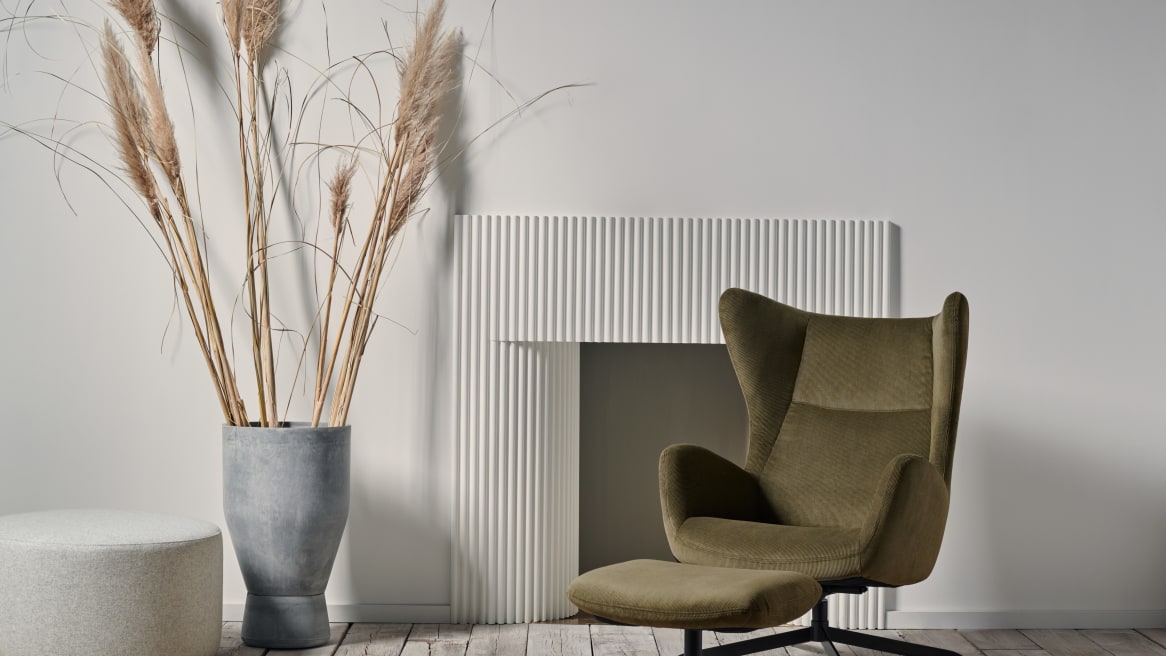 Solo Armchair in Home setting with pouf and Solo Footstool